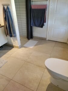 Badeværelse med fliser, håndklæder og toilet